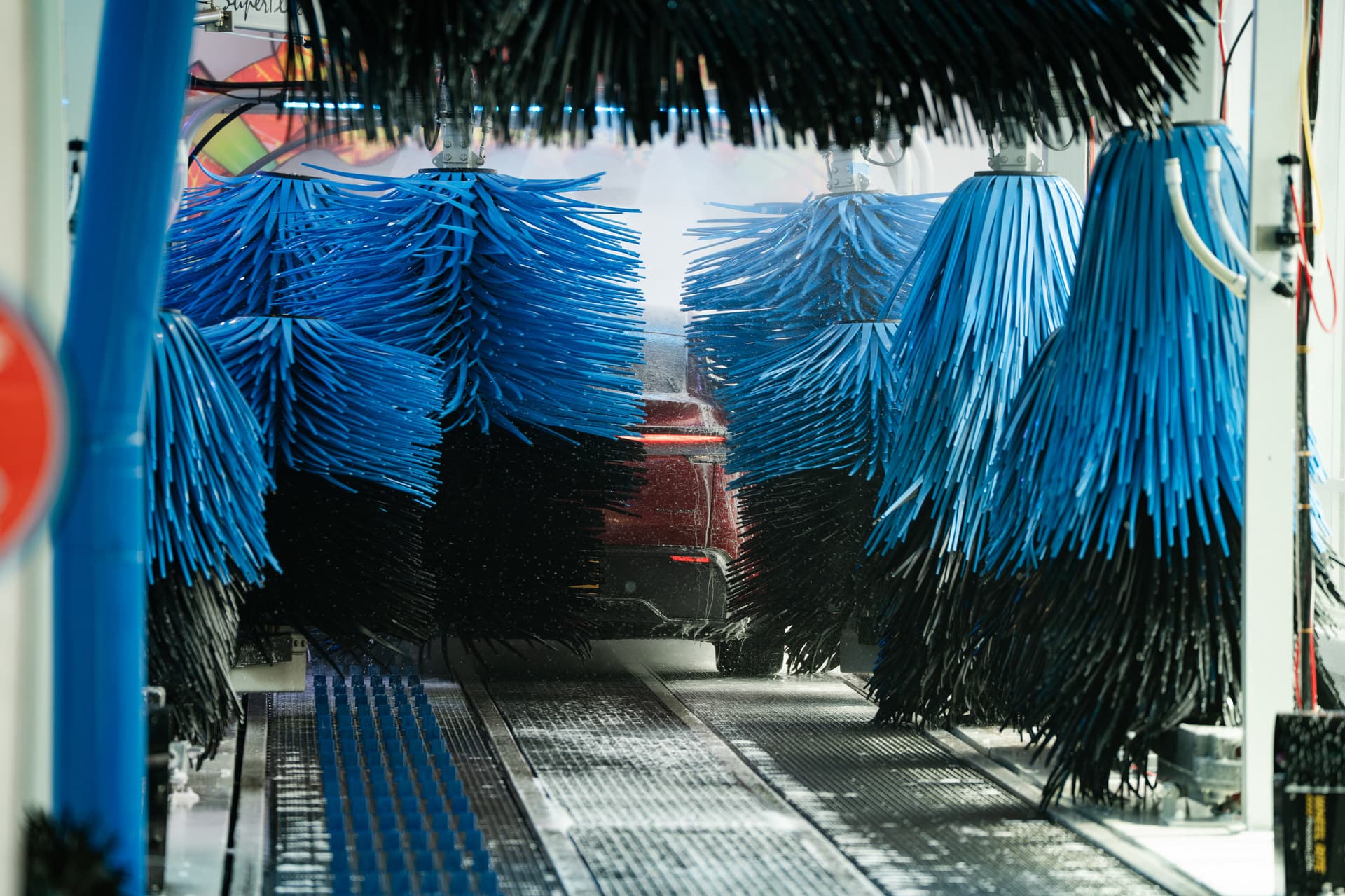 Coloured foam and ceramic coating being applied to a vehicle inside The Flow's wash tunnel