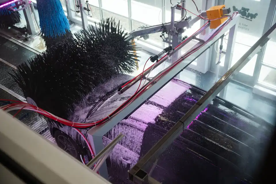 The closed-foam brushes inside the tunnel, retracted away from the vehicle for a touchless wash