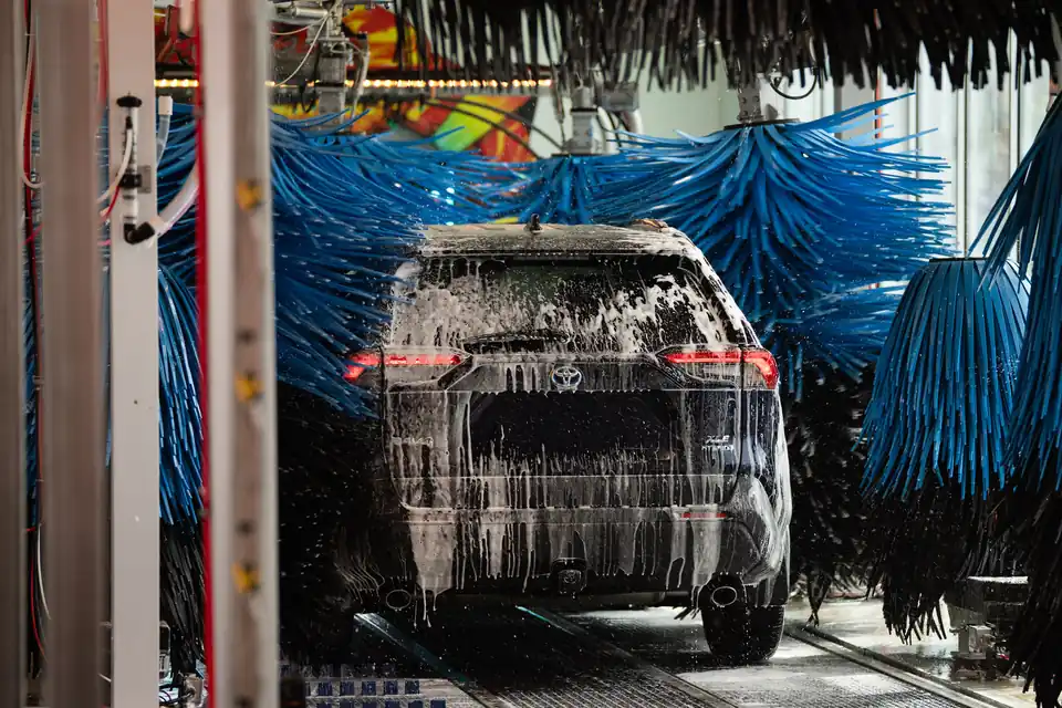 A freshly washed car leaving The Flow Express Car Wash with a clean, swirl-free finish